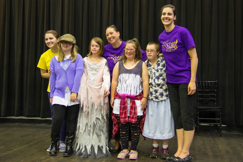 instructors smiling with group of girl students after showcase performance