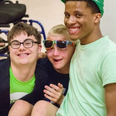 three boys embraced and smiling for the camera